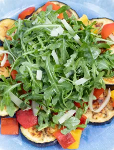 plate with sliced eggplant and arugula