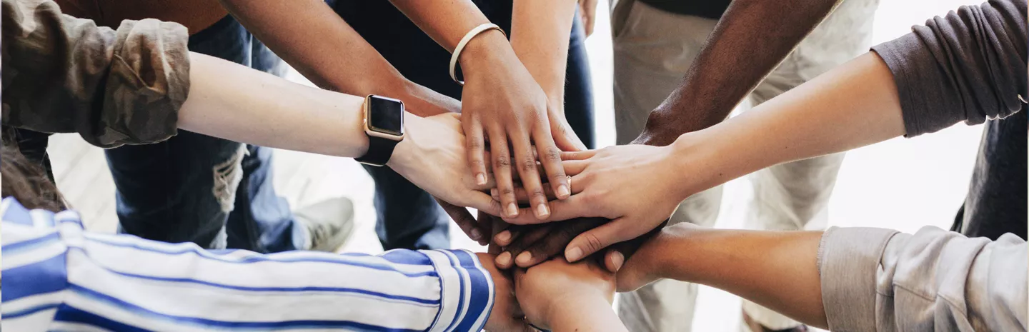 hands meeting in the center of a group