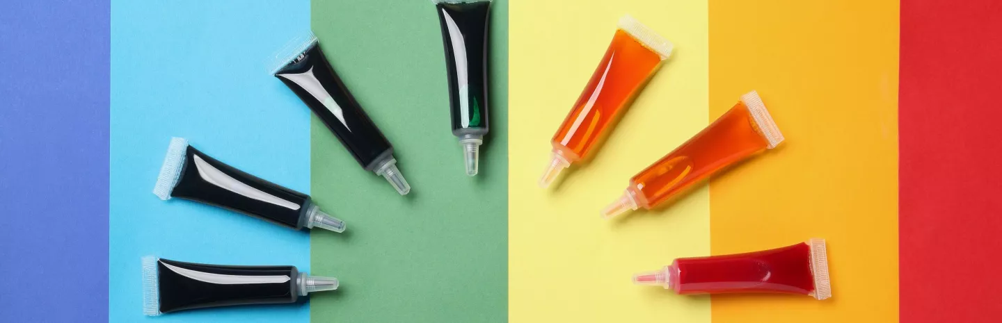 Tubes of commercial food dyes on a rainbow background