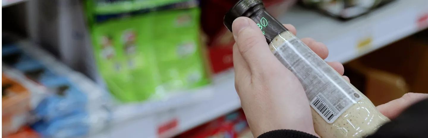 a person reading a product label in a grocery store