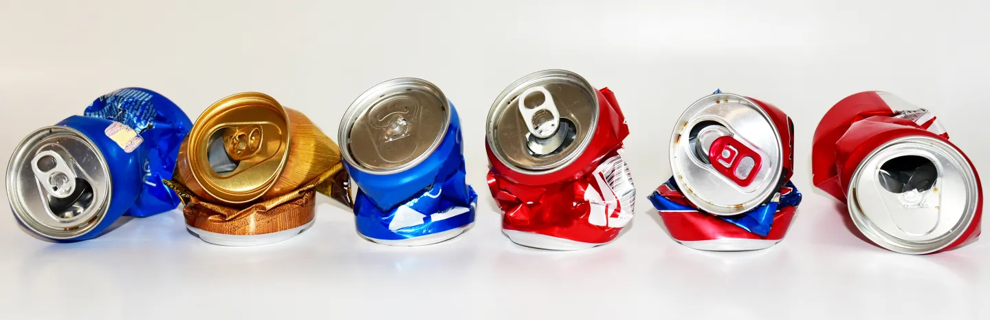 a lineup of flattened soda cans