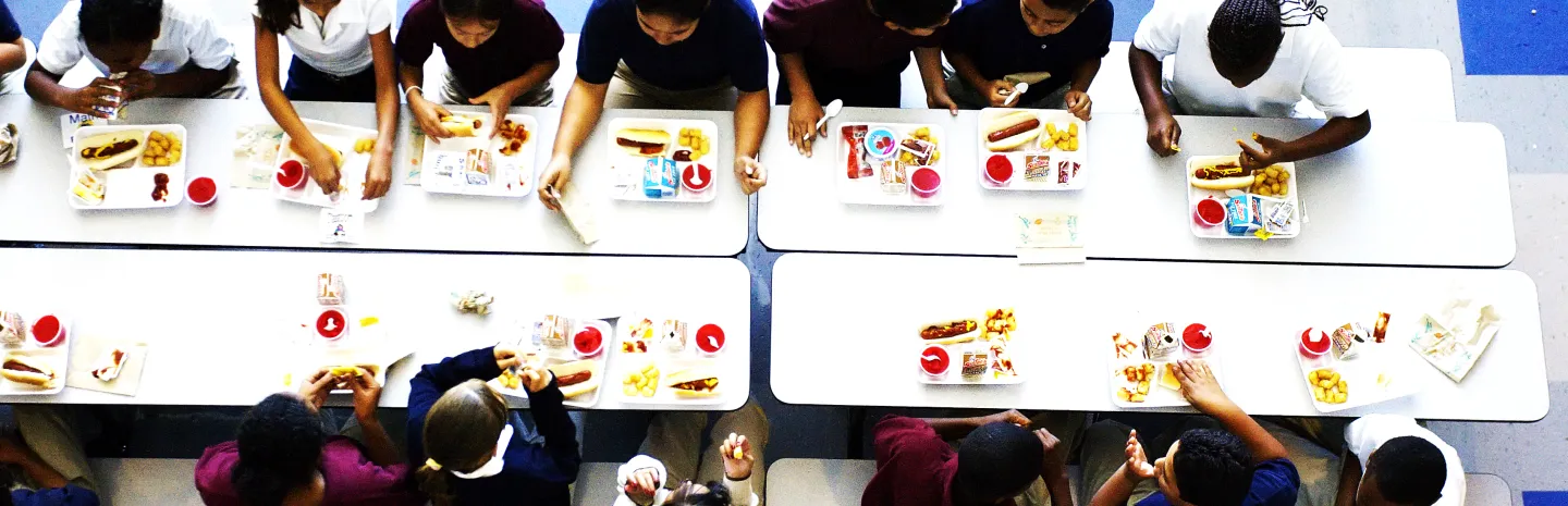 children in a school cafeteria eating lunch