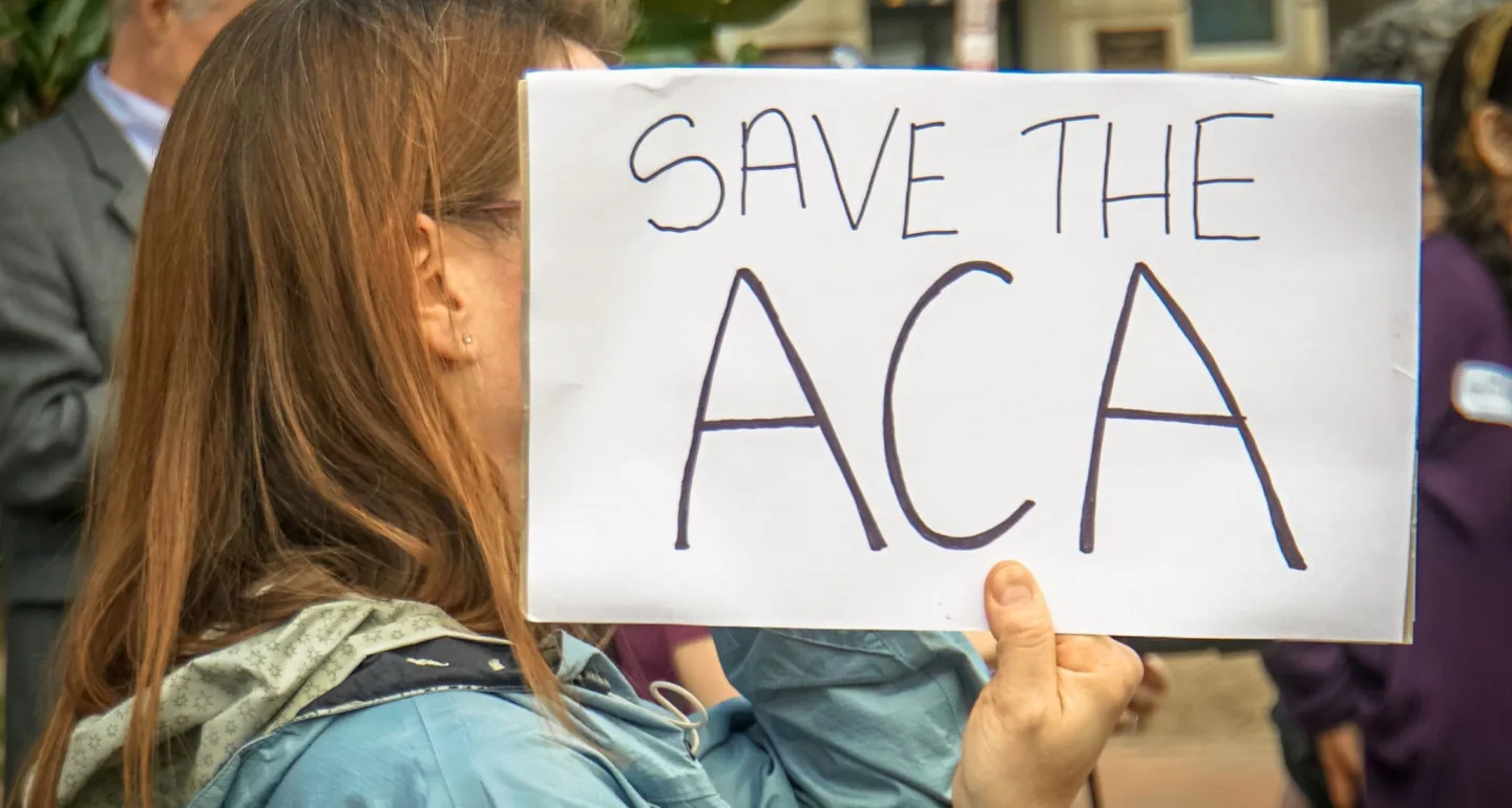 Rally in Support of the Affordable Care Act, at The White House, Washington, DC USA, carrying a sign that reads "SAVE THE ACA"