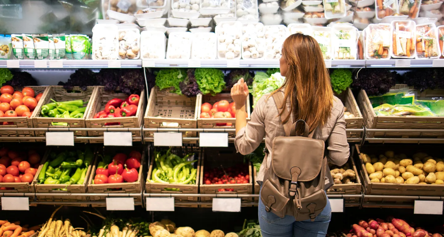 A woman shopping for produce in a grocery store