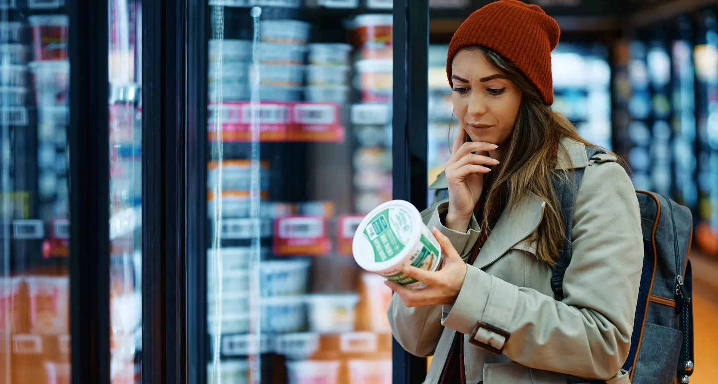 A woman in the grocery store reading the label on a product
