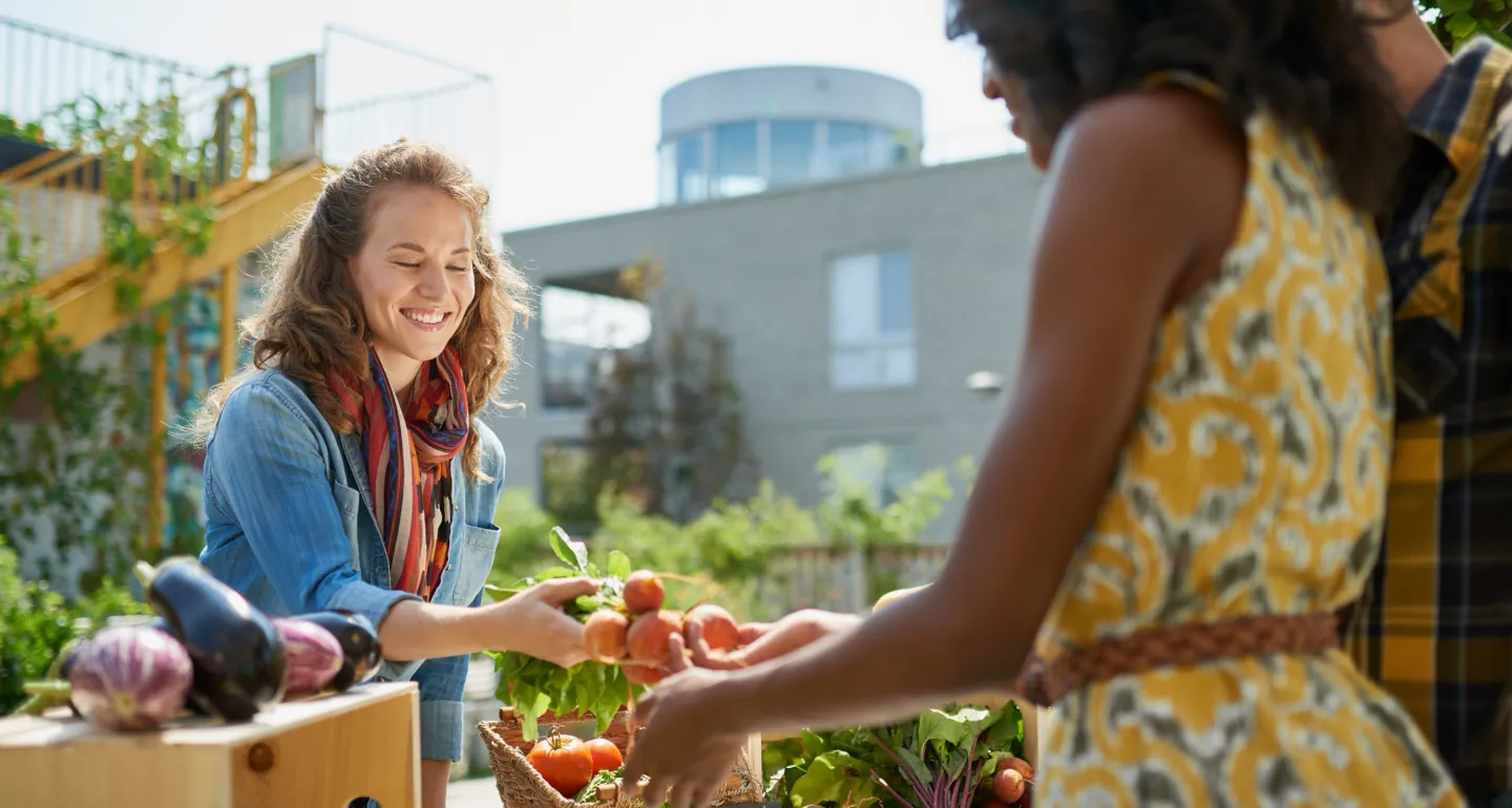 a woman selling vegetables at a farmers market