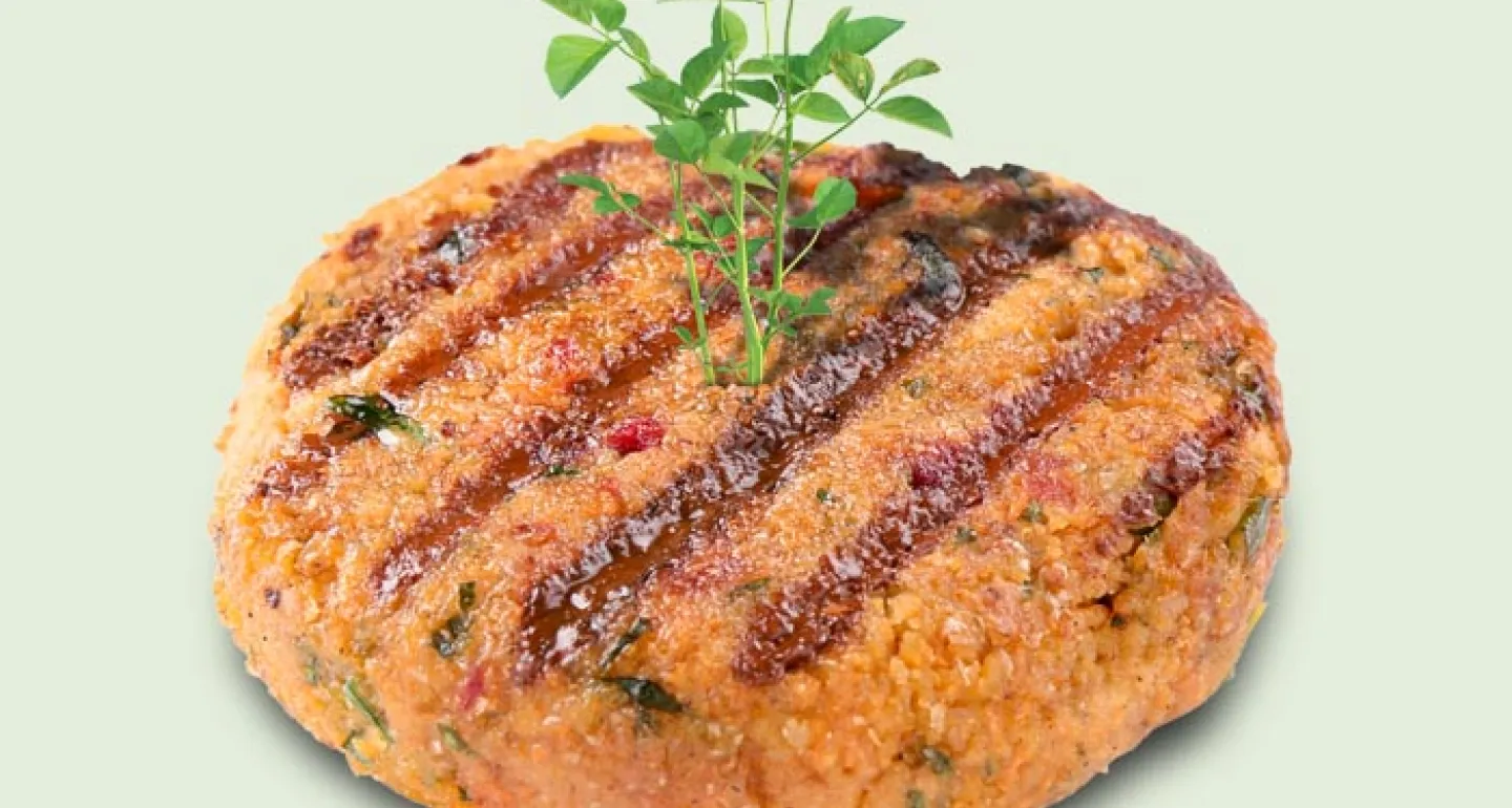 grilled plant based burger patty with green sprout coming out