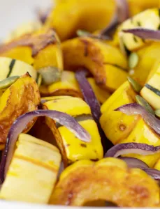 sliced delicata squash roasted and topped with sliced onions