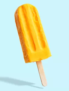 yellow popsicle on light blue background 