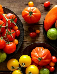 Seasonal produce - a variety of tomatoes in different sizes and shades of green, yellow, orange, red and purple