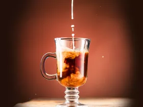 mug of coffee with creamer being poured in