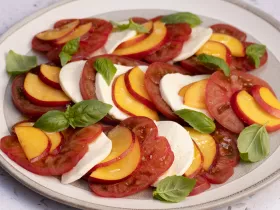 Plate with tomato, mozzarella, nectarine slices and basil