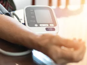 person using at at-home blood pressure monitor