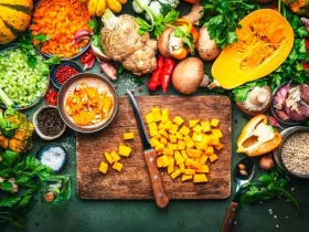 Sliced pumpkin, vegetables, mushrooms, root vegetables, spices, wood cutting board. Thanksgiving Day preparation. Healthy eating, slow food.
