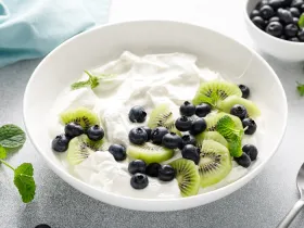 bowl of yogurt with blue berries and kiwis