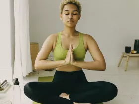 woman sitting crisscross with prayer hands as a yoga pose 