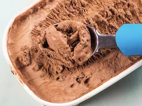 ice cream scoop in a 1.5 quart tub of chocolate ice cream