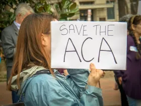 Rally in Support of the Affordable Care Act, at The White House, Washington, DC USA, carrying a sign that reads "SAVE THE ACA"
