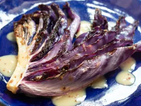 red cabbage leaf with honey mustard sauce on indigo plate