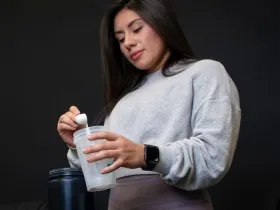 woman scooping powder into clear cup