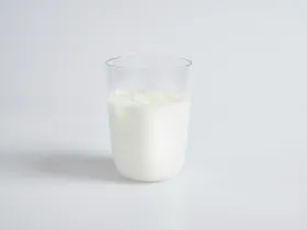 A cup of milk on a white table.