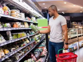 A man shops for bagged salad