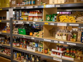 Food bank shelves containing dried and canned goods