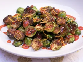 plate of Brussel sprouts halved, roasted and covered in a sauce