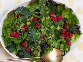 large plate filled with salad greens and berries
