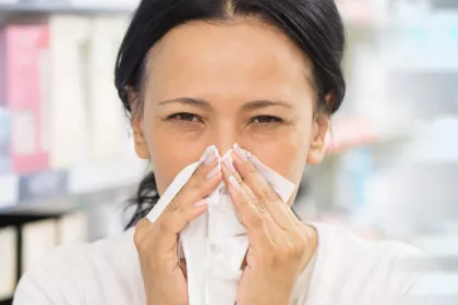 woman wiping nose with tissue