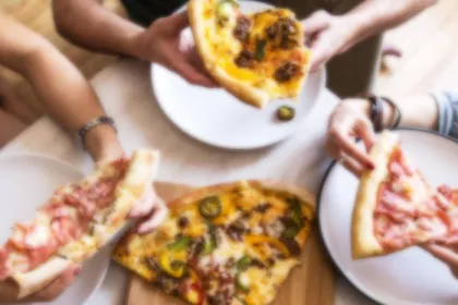 people eating pizza around table
