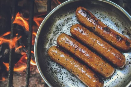 sausages sautéing over a fire