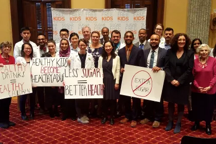 A diverse group holding signs supporting sugar free kids