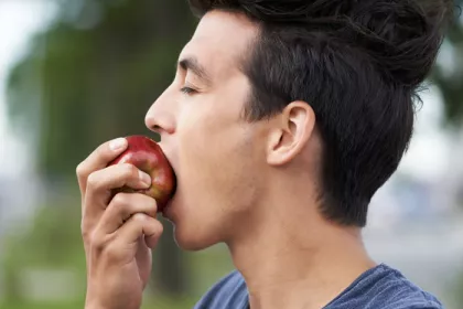 person biting an apple