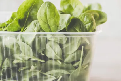 spinach leaves in clear plastic carton