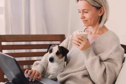 woman sitting with dog, sipping coffee