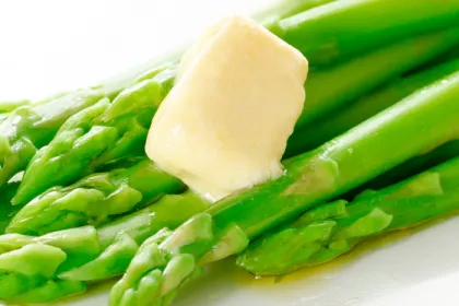 green asparagus stalks with melting pat of butter 