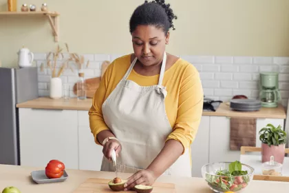 Woman cutting an avocado in bright kitchen