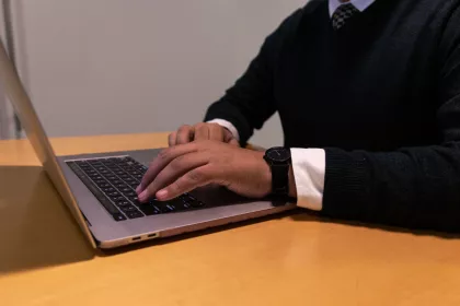 A pair of hands using a laptop