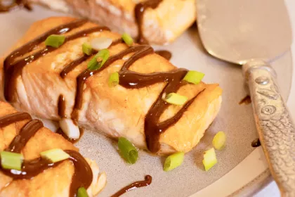 salmon drizzled with black garlic sauce and scallions