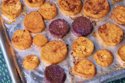 baking tray with sliced sweet potatoes covered in spices