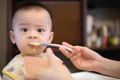 Baby being fed baby food.