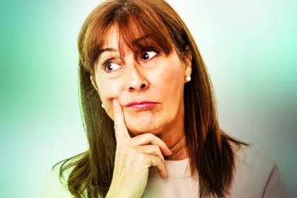 woman in a thinking position on blurred green background