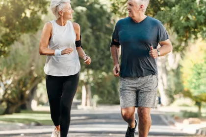 older man and woman jogging outside