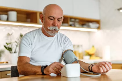 Man taking his blood pressure in the kitchen