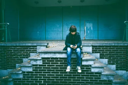 A middle school aged boy watching a video on his phone