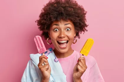 a woman holding popsicles
