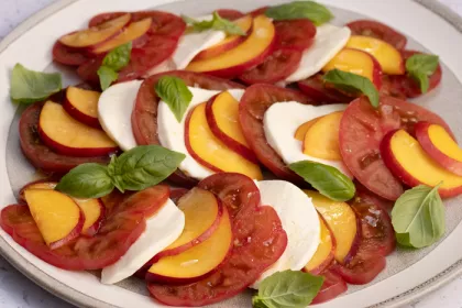 Plate with tomato, mozzarella, nectarine slices and basil