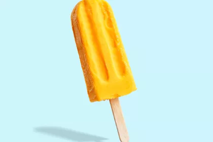 yellow popsicle on light blue background 