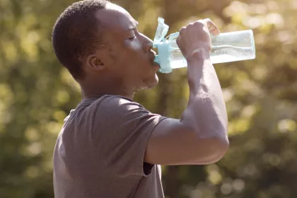 man drinking water from a reusable water bottle